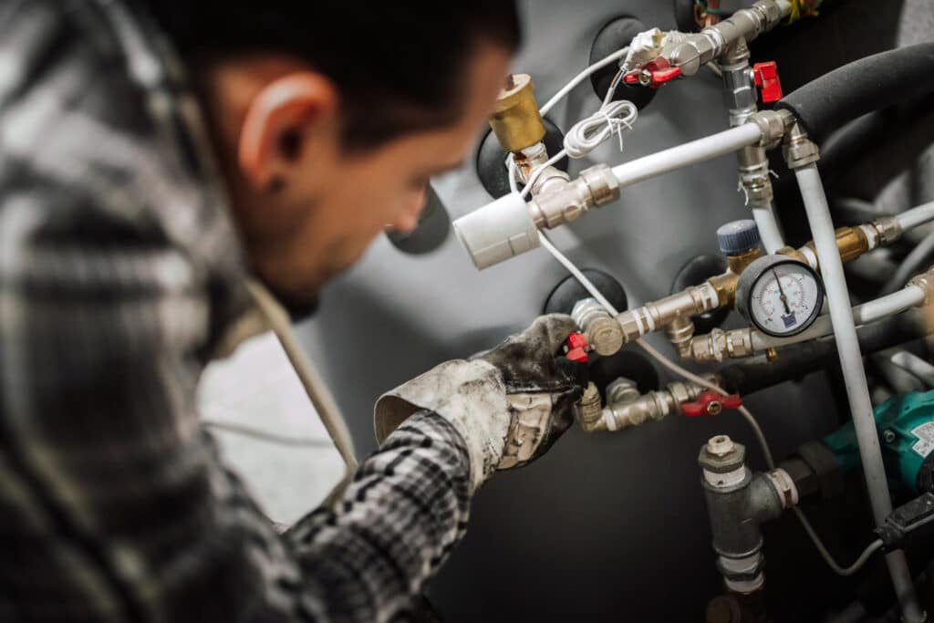 Close up photo of a man fixing the pipes at home.